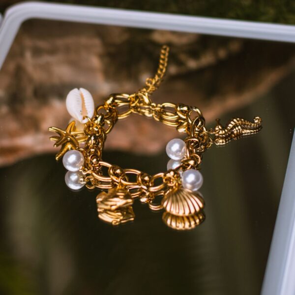 Gold-tone shell and pearl charm bracelet