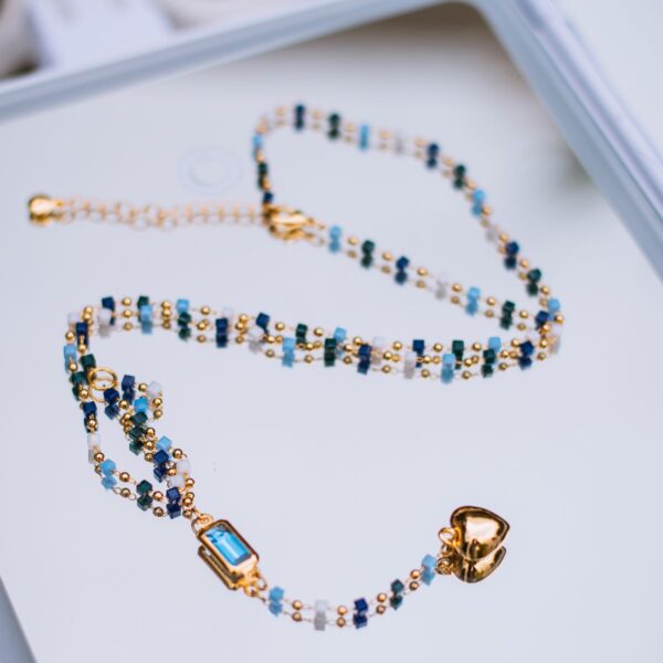 Blue and gold-tone bead necklace with pendant