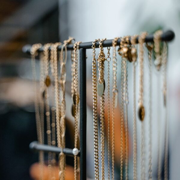Gold-tone long chain necklaces on a stand